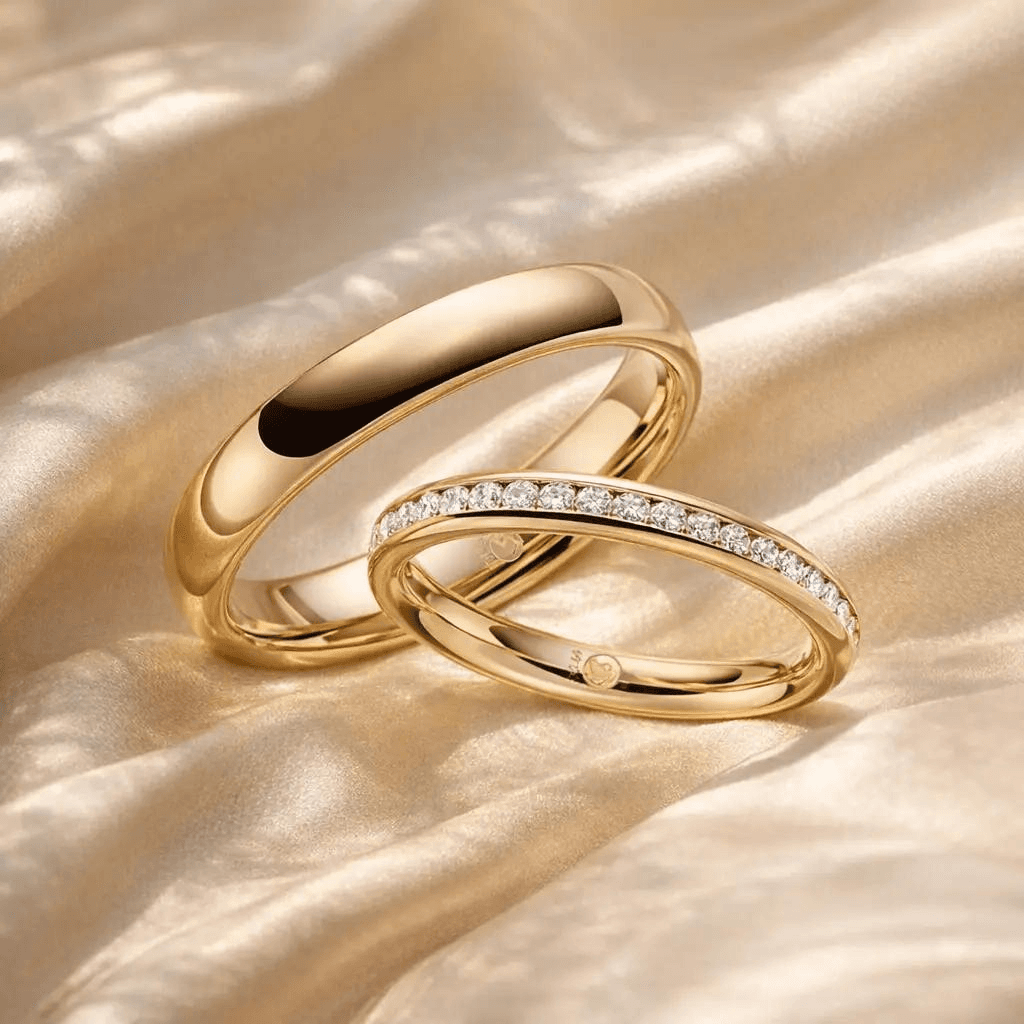 Zwei goldene Trauringe auf Seide, einer mit Diamanten